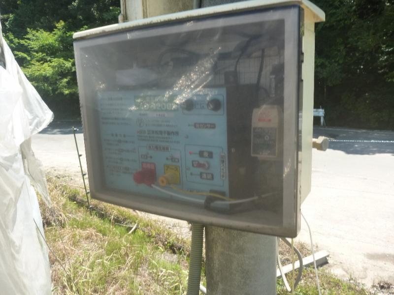 (写真)四角い箱に格納されている電気さくの電源装置
