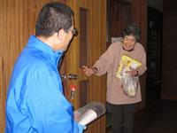高齢者宅を尋ねる京都生活協同組合の職員と、訪問先の女性の写真