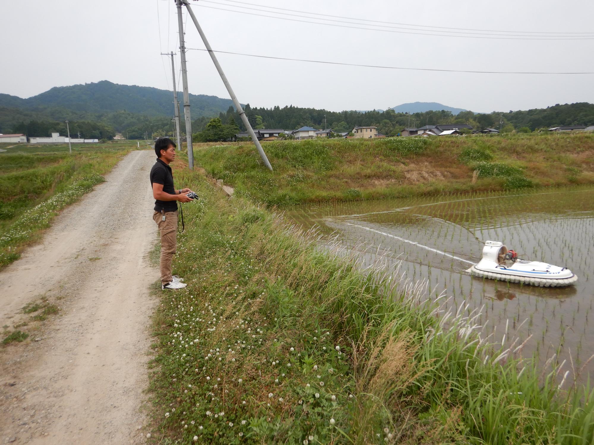 ホバークラフトを使って除草剤散布を行う昭公さん。省力化も農業の重要なポイント