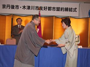 固い握手を交わす中山泰京丹後市長（左）と 河井規子木津川市長（右）